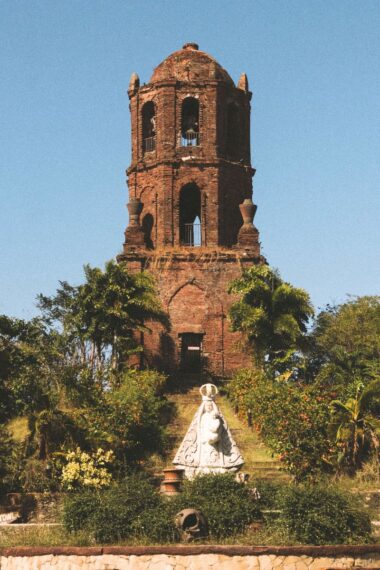 Historic red-brick bell tower under blue sky