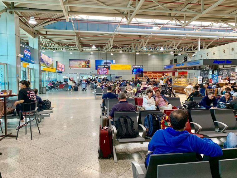 Airport terminal filled with many people