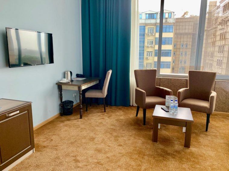 Hotel room with a tv, chairs, cabinet and other things