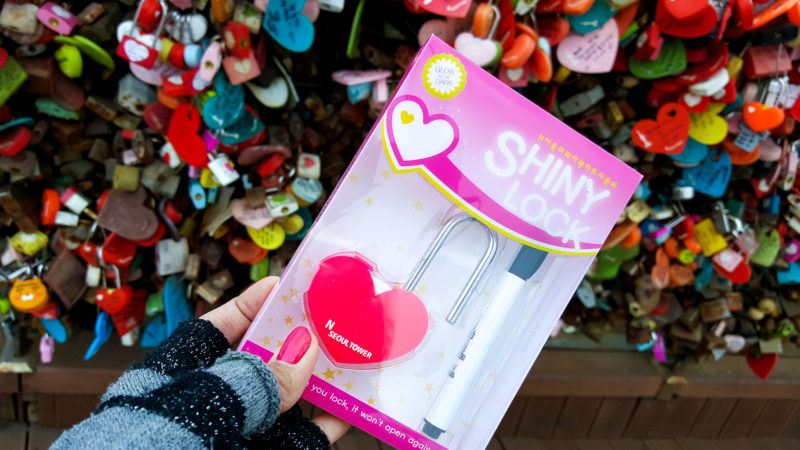 Hand holding up a newly-bought love lock
