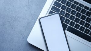 A laptop and a phone on a grey table