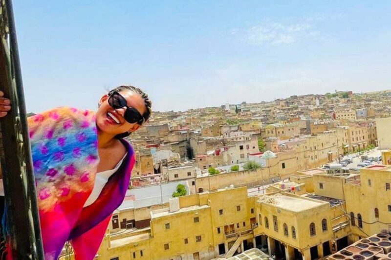 Girl holding onto a post with houses in the background