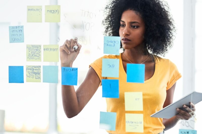 A girl writing on a transparent board