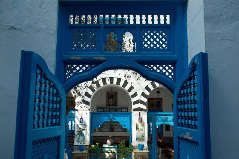 White walls are divided by large blue gates