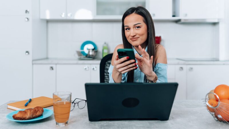 Woman at the desk with her phone and laptop