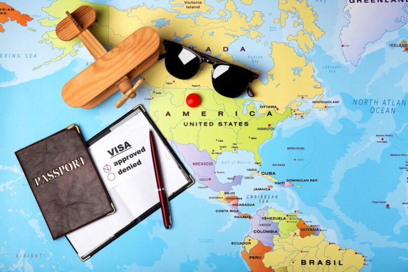 A map with a toy plane, passport and sunglasses on it