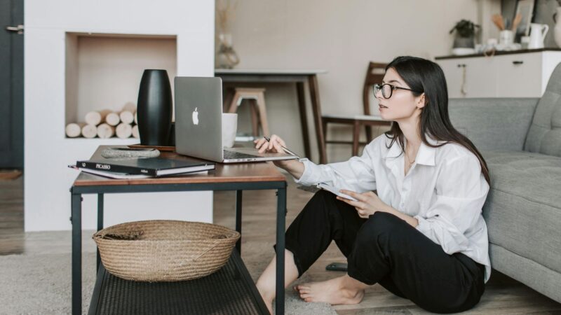 Woman sitting on the floor and working on laptop