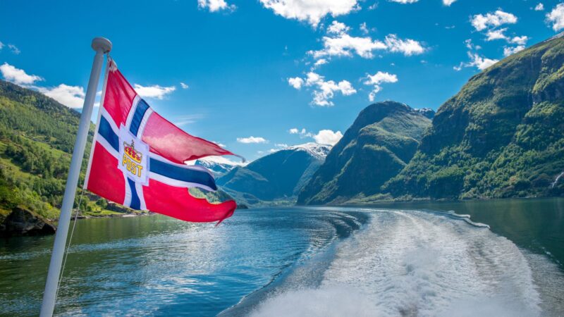 The Norway flag on a boat passing by on a river