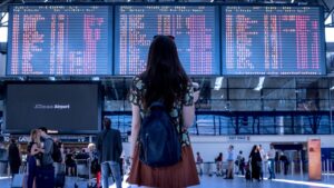 Girl in front of digital board for flight announcements