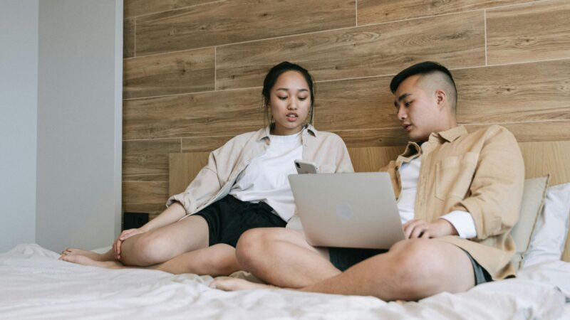Couple on the bed with a laptop talking