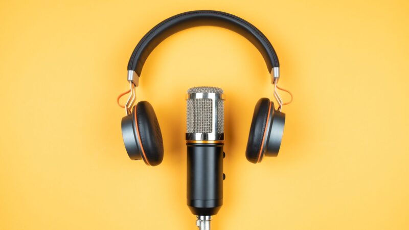 Headphones surrounding a mic on a table