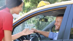 A woman talking to the driver of a taxi