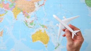 Map with a hand holding up a plane